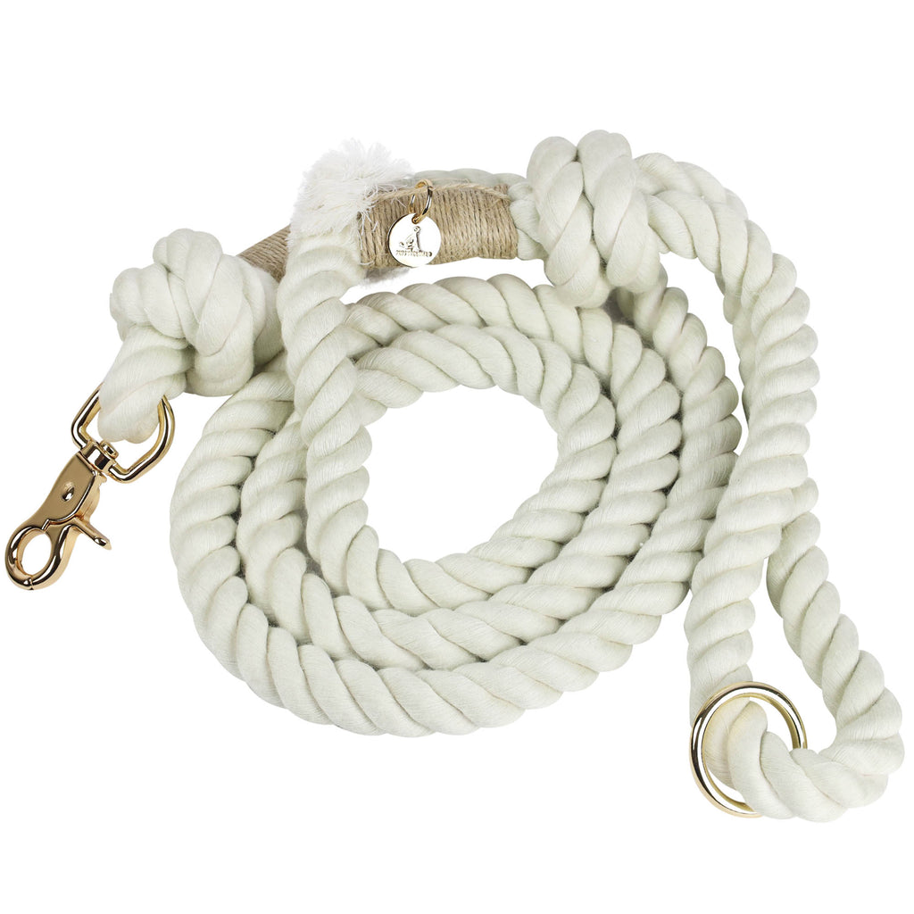 Handmade cream colored cotton rope dog leash coiled neatly with gold hardware clasp, O-ring, and Puppysentials charm, highlighting durable and elegant design.