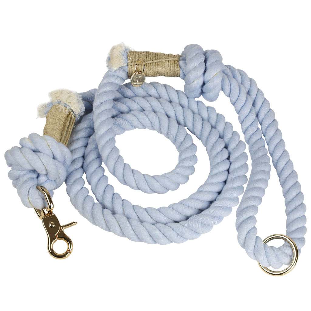 Handmade and hand-dyed blue cotton rope dog leash coiled with gold hardware clasp, O-ring, and Puppysentials charm, showing durable and stylish artisan design.