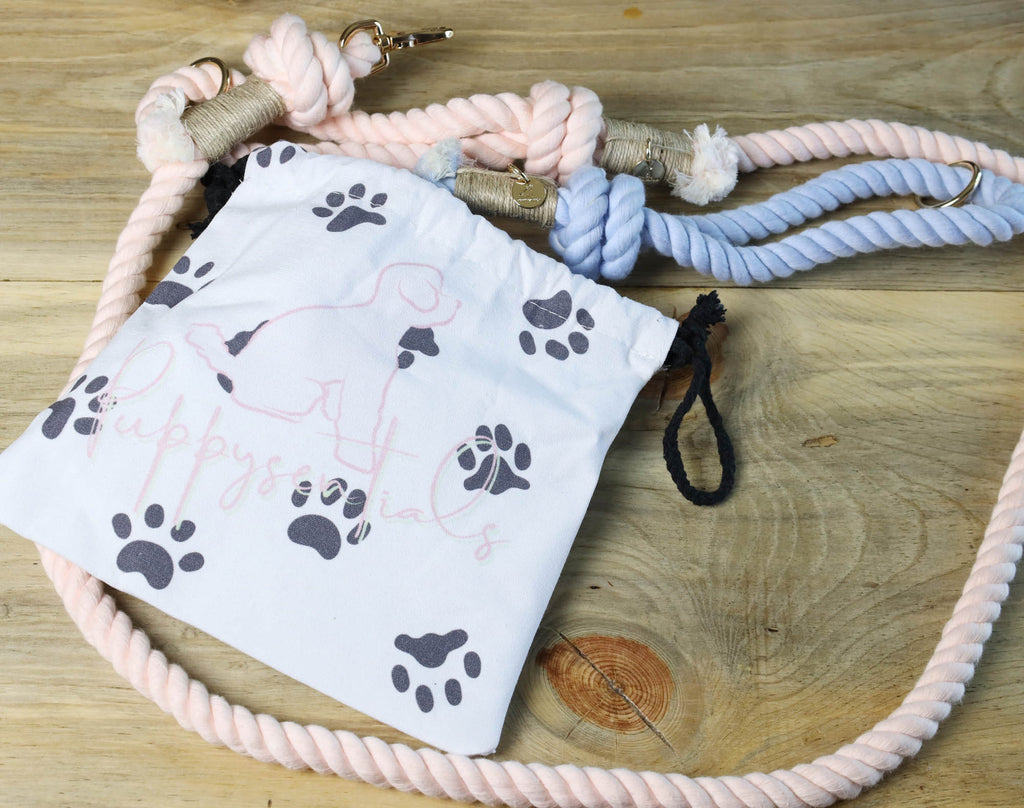 Handmade cotton rope dog leashes in pink and blue displayed with a Puppysentials cotton gift bag, perfect for storage, washing or gifting.